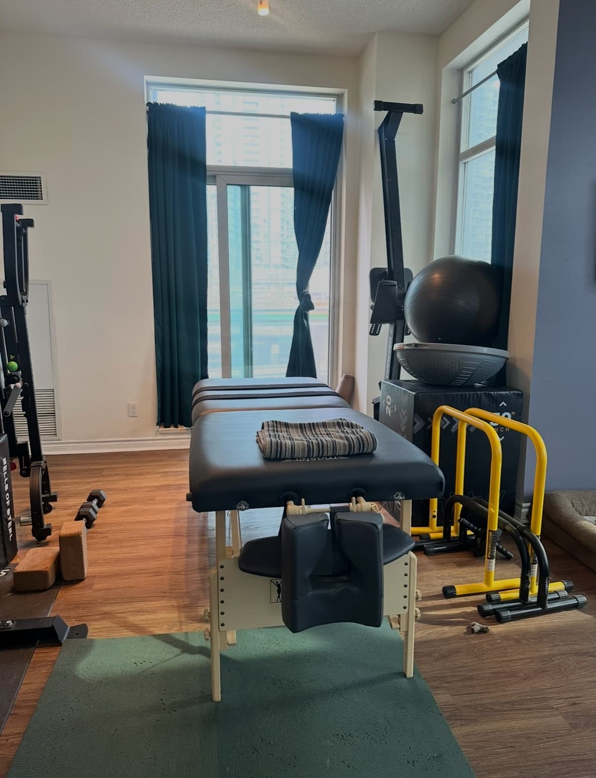 Registered Massage Therapy treatment room with massage table and fitness equipment